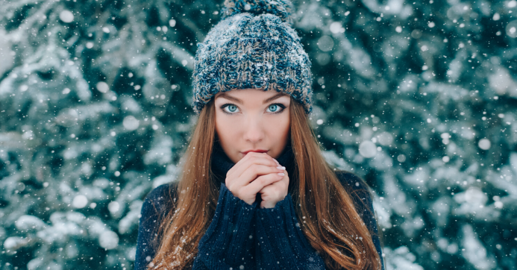 Retrato de Navidad de hermosa niña con sombrero con nieve