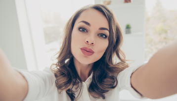 Chica joven y morena con los labios pintados se hace un selfie en este articulo sobre labiales favoritos y qué los hace tan especiales